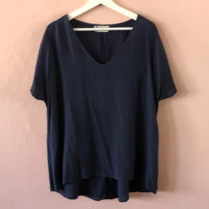 Mörkblå Sidentopp - Fin Vringad t-shirt i Sidén/silke. Längre bak än fram. Faller snyggt på kroppen. 