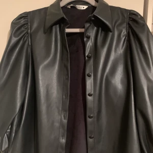 Skinnskjorta - Skinnskjorta från ZARA! Ballongärm, och ärmen slutar vid armbågen. Använd fåtal gånger! Nypris 399kr har jag för mig. Frakt tillkommer.