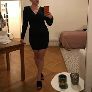 Svart tight klännkn - Svart tight klänning i stretchtyg. Insydda puffar i axlarna. Använt 1 gång 