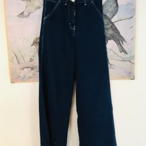 Jeans från Arket - Vida mörkblå jeans från Arket. Rå kant vid foten. Köpta på Plick men var tyvärr för små. Storlek 34. Lite lite stretch men inte så mycket. Säg till om du vill ha fler bilder 👖