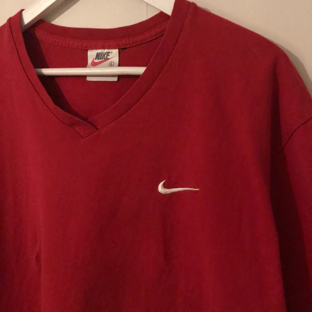 Vintage Mini Swoosh Nike t-shirt med v-neck. T-shirten är från 90-talet och är Made In Usa. I bra skick förutom två hål som man kan få bilder på. Storlek XLARGE.. T-shirts.