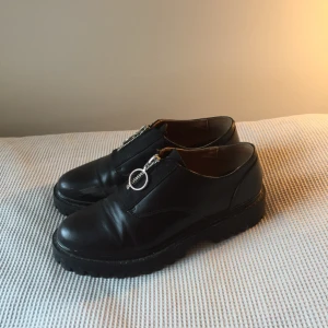  - svarta skor i fakeskinn med blixtlås. använda lite men de enda fel som syns är slitningar på insidorna av foten på båda skorna (se foton), därav priset. annars bra skick!