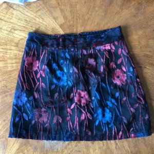  - Kort svart kjol med sammetsmönster köpt på humana. står storlek S i den men skulle säga att den är XS. Undertyget är svart och det över är genomskinligt med sammetsblommor. Kan mötas i Stockholm eller så betalar köparen frakt!