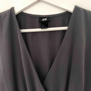  - Festlig grå klänning från H&M i storlek 34. En aning nopprig på baksidan. Kan mötas upp i Stockholm eller så står köparen för frakt