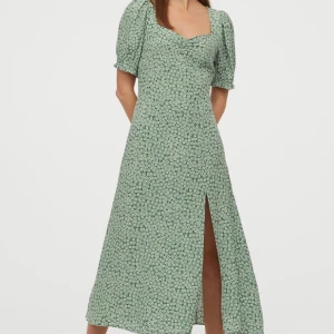 Grön/Blommig klänning HM - Underbar lite längre klänning från Hm, aldrig använd! Kostar 159kr nu i butik. Hojta till vid frågor!