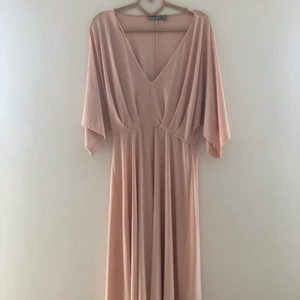 Klänning ASOS - Perfekt klänning för bröllop eller finare fest. Inköpt för cirka 1,5 år sedan men endast använd på ett bröllop en gång.   "Tungt" tyg som skapar ett jättefint flow i klänningen.   Inköpt för cirka 850 kronor