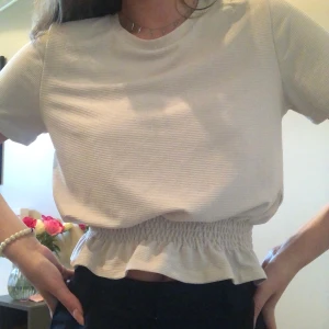 Söt tshirt - super söt T-shirt med resår i midjan. Beige färg. Sparsamt använd. Frakt tillkommer