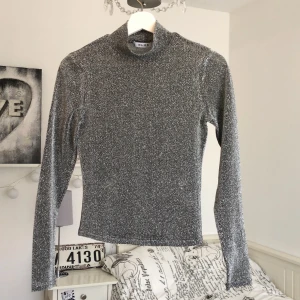 Glittrig tröja  - Säljer denna glittriga tröjan från NA-KD, den är väl använd men fortfarande i fint skick. På bild två ser man att den är ganska genom slinkig. Om du är intresserad tveka inte på att skriva till mig☺️. FÖRST TILL KVARN⚠️ KÖPAREN STÅR FÖR FRAKTEN⚠️