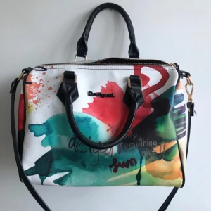 Färglagd väska från Desigual - Säljer denna supersnygga väska från Desigual! Köpt för några år sedan men är helt oanvänd och där och med i nyskick. 💙💜 två band tillkommer, både det längre på bilden och ännu ett längre band. GE PRISFÖRSLAG! priset som står är exklusive frakt!!