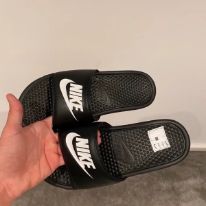 Nike Tofflor! - Helt nya, oanvända, svarta nike tofflor! Storlek: 42,5. Nypris: 500kr. Kan mötas upp i Göteborg eller frakta. Det är bara att höra av dig om du är intresserad :)