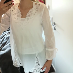Odd molly - Vit blus med blommiga detaljer. Supergulligt sydd i ryggen. Lite längre än midjan. 