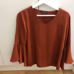 V-ringad topp  - En sprillansny orange v-ringad topp från Shein med volangärmar. Säljes då den inte riktigt passar min stil. Har aldrig använts. 