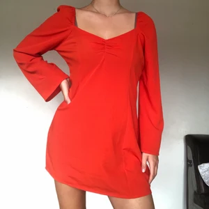Röd klänning från Collusion, strl 42 - Röd klänning från Collusion, strl 42, men skulle beskriva den mer som 40 i passform, jag är 175 cm.Knytning baktill möjliggör för personer med något mindre storlekar att kunna bära den! Material som andas, fint fall. Knappt använd! Köparen står för frakt🥰