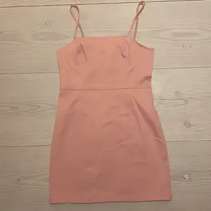 Rosa klänning från hm i stretchigt jeans material, ganska kort, man kan inte justera banden, den har en silvrig dragkedja på baksidan och sömmar längst hela klänningen på framsidan av och baksidan 