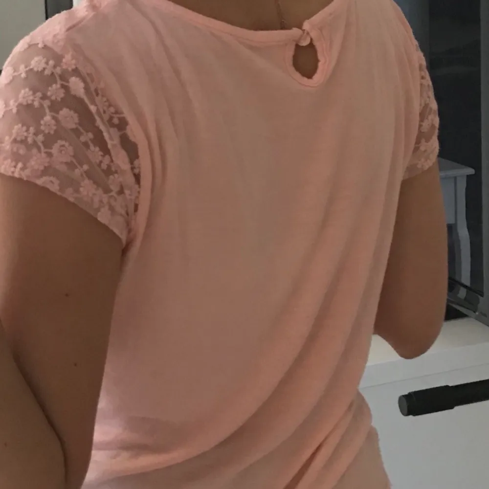 En rosa blommig T-shirt i storlek XS/S. T-shirts.