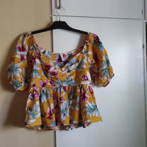 Blommig Peplum blus  - Blus från newyorker, den har en dold dragkedja på ena sidan och Peplum under bröstet 