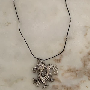Halsband - Ett jättecoolt halsband som jag gjort själv som har en stor silver drake och silver detaljer🤩 75kr (inkl frakt)⚡️ Har ett fäste där bak✨ Tillkommer i en fin liten påse😍 Först till kvarn!! Kontakta mig vid frågor och intresse🥰