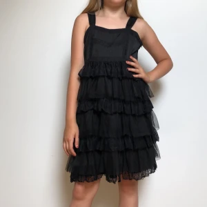 Svart klänning med hängande volanger - Har aldrig används tidigare, men passar perfekt i midjan och uppe vid axlarna👍🏻Funkar som en halloween dräkt även.