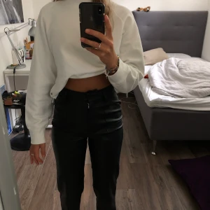 Faux läderbyxor med sömmar framtill - Ett par as coola faux läderbyxor från h&m med fina detaljer framtill. Det är lite korta på mig som är 170 cm, de är storlek 34. Har nästan aldrig använt dom, så skicket är prima. Köptes för 300kr, så budgivning starta från 200kr
