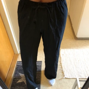 Byxor - Svarta ”fladderbyxor” med skrynkligt material. Sydda av min mamma. 50kr+frakt.