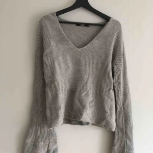 - Grå stickad tröja från BikBok. Vida ärmar, v-ringad. Köparen står för frakten! 