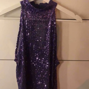  - En jättesnygg topp med paljetter. Toppen har en halterneck och är lite öppen under armarna. Ett så snyggt plagg nu till våren som tyvärr inte kommit till användning. Helt oanvänd! Pris kan diskuteras, vill bara bli av med massa kläder.