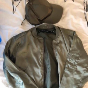  - Snygg bomberjacka med tillhörande keps i snygg färg för våren. Storlek XS men passar även S. 