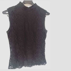  - Svart mönstrad polotopp som passar till såväl jobbmötet som festen. Fint skick! Fr Åhléns. 