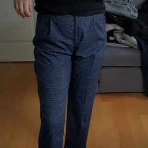 Snygga mörkblå/grå kostymbyxor - Ett par kostymbyxor från Monki. Strl 38. Använda fåtal gånger och mycket bra skick. Jag står för frakten. Kan dock mötas upp i alsike/knivsta/uppsala