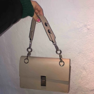  - Säljer denna sjukt snygga handväska, beige med nitar som detaljer. Kan mötas upp i Stockholm annars står köparen för frakten🥰 priset kan diskuteras 