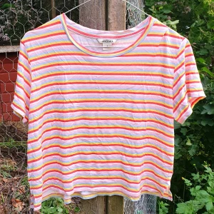 Monki kort randig t-shirt (S) - En söt och färgglad t-shirt från Monki <3 Mjukt och tunnt tyg, skulle nog passa med ett par blå jeansshorts och söta skor! Bröstlängd 47cm; Plagglängd 35cm; Passform: Rätt så stretchig, når ner till naveln