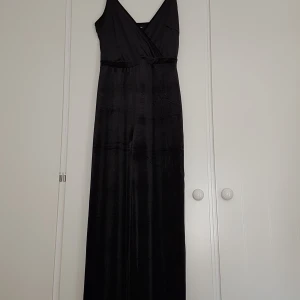 Svart byxdress i plysch/sammet  - Svart byxdress/jumpsuit i plysch/sammet-liknande tyg. Storleken är i M men passar även som L, passformen är bra. Har endast använt den två gånger så den har inga tecken på slitage. 