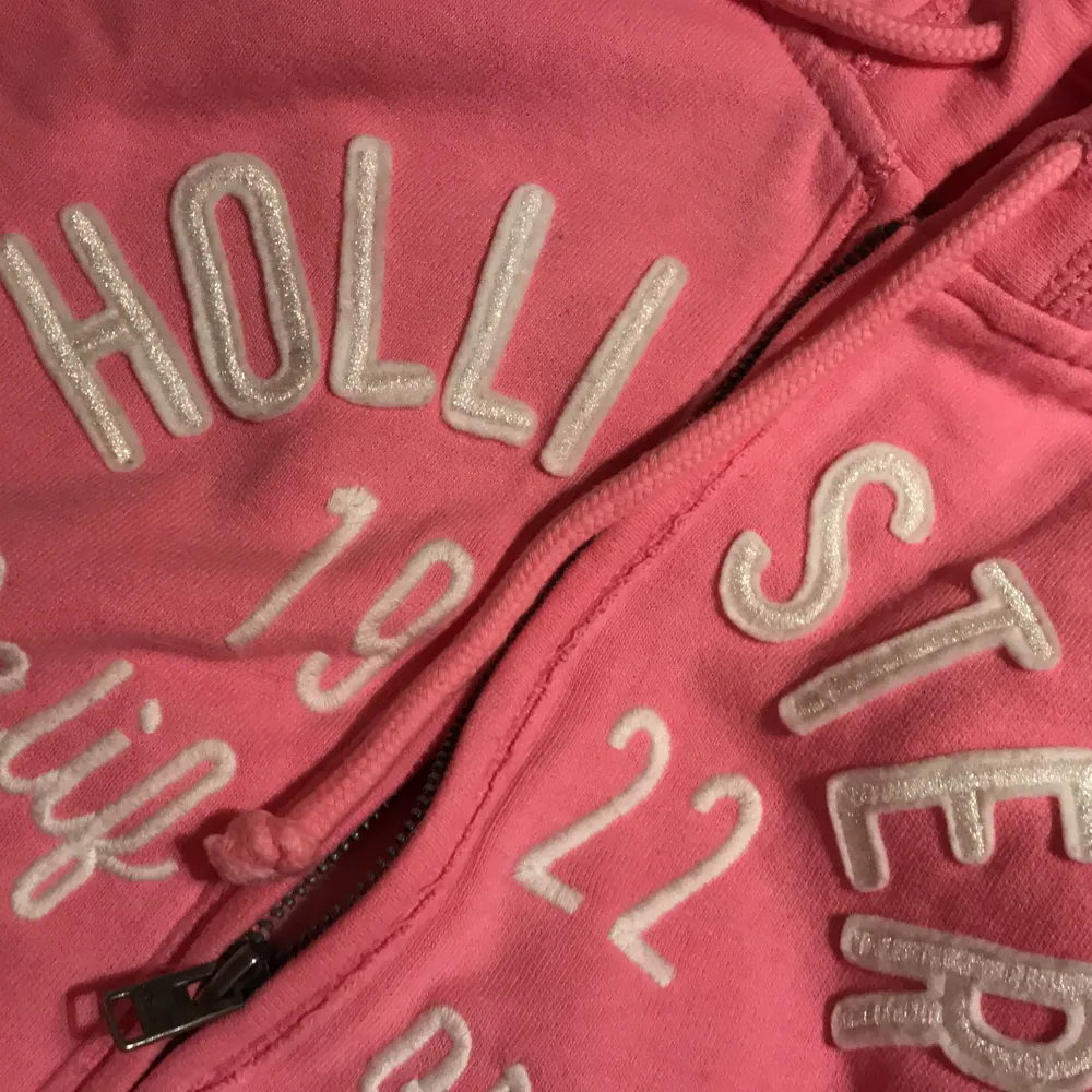 Rosa hoodie från hollister. Köpt för några år sedan men knappt använd och i gott skick. Glittrig logga och finns ”lucka” för hörlurssladd i fickan!. Hoodies.