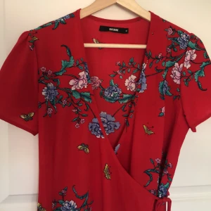 Blommig omlottklänning  - Jättefin blommig omlottklänning från bikbok, använd ca 2 gånger så i fint skick! Köparen står för frakt 🌺