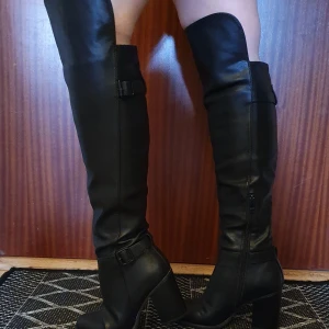 Högklackade svarta stövlar. Stl 36 - Nästan helt oanvända, snygg modell, passar till både byxor och kjol/klänning.