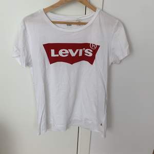 Levis T-shirt i fint skick förutom några fläckar längre ner. Man skulle kunna kippa av den till en crop top tex! Frakt tillkommer!