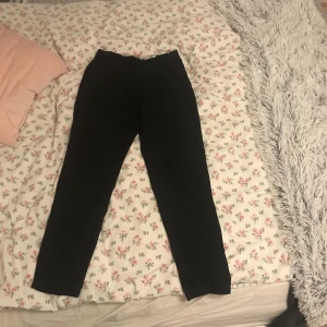  - Enkla, svarta byxor. Inget märkvärdigt. Resår i midjan (på ryggsidan) och knapp fram 