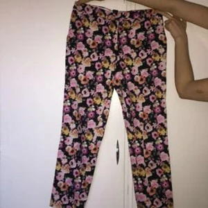  - Blommiga byxor i Strl 38 från H&M. Svart bas med rosaaktiga blommor. Fin passform.