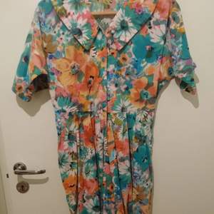 Retro jumpsuit/byxdress i härliga färger. Passar medium eller large beroende på hur man vill att den ska sitta. Vissa sömmar kan behöva bättras på om man känner för det. 