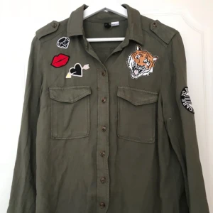  - Grön skjorta med olika märken på från hm Köparen står för önskad frakt