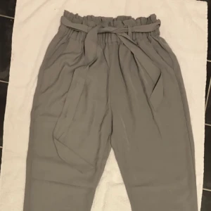  - lite ”kostym” aktiga gråa byxor i storlek XS. Från Bikbok, aldrig använda. Frakten får du stå för själv.