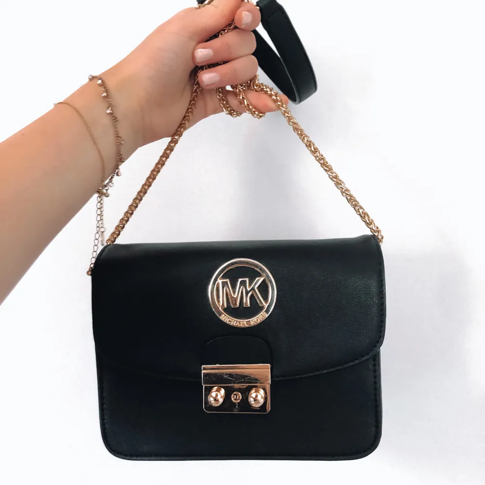 MK-väska som ej är äkta men ändå väldigt fin och upplevs vara av bra kvalité med lås som går att stänga samt fack inne i!. Väskor.