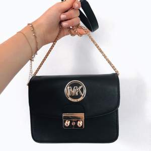 MK-väska som ej är äkta men ändå väldigt fin och upplevs vara av bra kvalité med lås som går att stänga samt fack inne i!