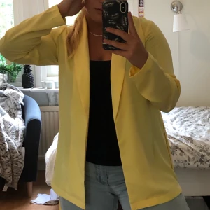 Gul Blazer - Skitsnygg blazer i luftigt material. Kan bäras både öppen och igenknuten. Storlek 36, passar S-L. Använd ett fåtal gånger. 🥳 Har ni frågor eller funderingar är det bara att höra av sig. Köparen står för frakt 🚚.