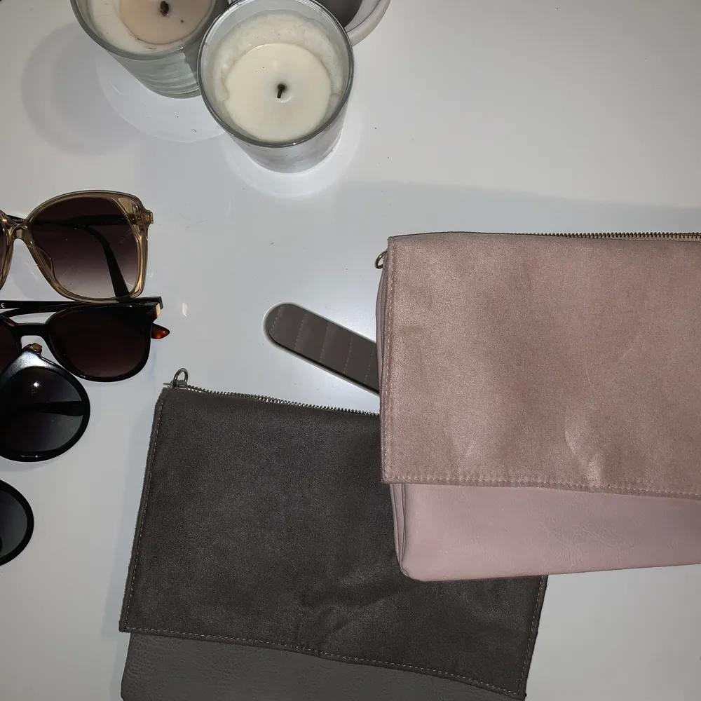 Två kuvertväskor från H&M, den gråa är helt oanvänd och den rosa är använd en gång, med en fläck som syns på andra bilden🌺 Båda för 100kr eller en för 60kr. Väskor.