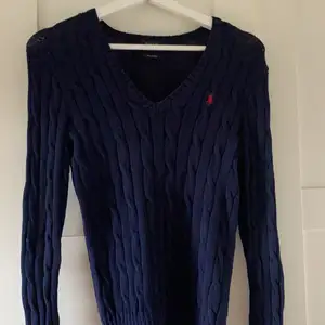 Säljer denna marinblåa kabelstickade tröjan från Polo Ralph Lauren. Använd en del men är i bra skick. Köparen står för frakten!