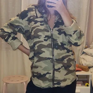 Långärmad militär tröja - Köpt på New Yorker, helt oanvänd då jag ångrar köpet. Storlek XS/S. Har en ficka på framsidan och luva ingår på tröjan. Dragkedja så man lätt kan sätta på och ta av. Jätte fin att styla med olika nyanser av tröjor under. 