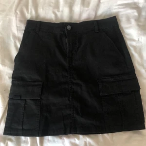 Svart kjol - Svart cargo kjol i storlek S. Aldrig använd så den är i helt nyskick. 