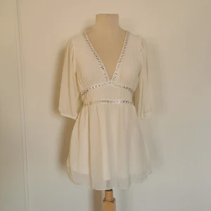 Blus - Vit blus med silverdetaljer, transparenta armar. Märke: Gina Tricot. Storlek: S, men kan även användas som M. Skick: väldigt fint. Använd ett fåtal gånger. Pris: 80 kronor eller bud. Frakt: Betalas av köparen. 