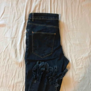 Jeans byxor i mörk tvätt med tråd nertill  - Högmidjade mörkblåa jeans med fransar nertill. Super coola ankeljeans med snygg passform och tjockare tyg med stretch. 